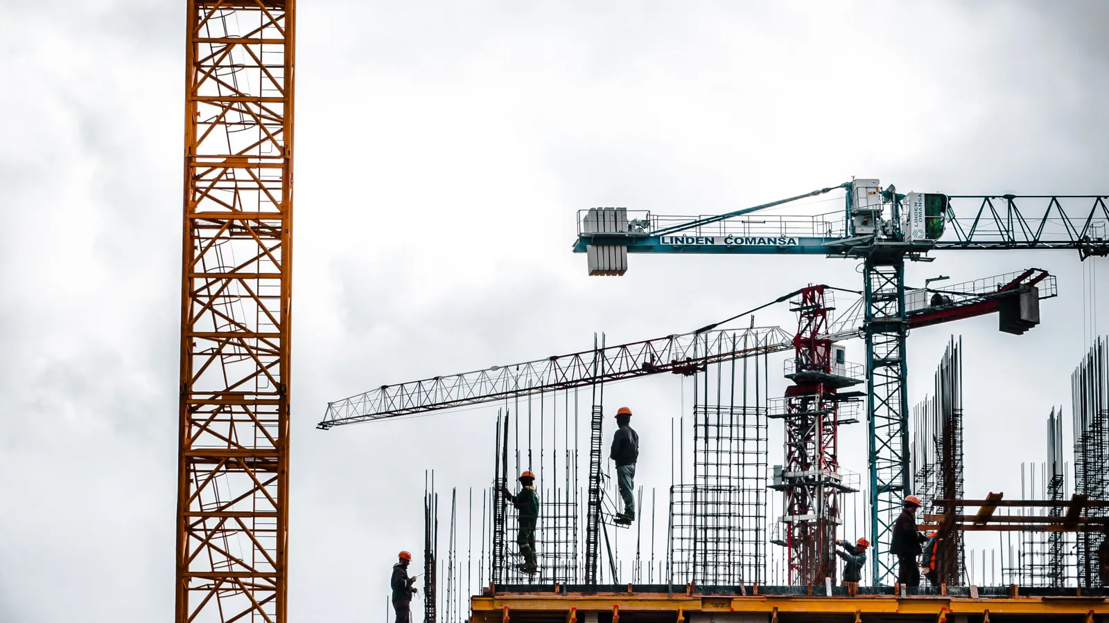 Obra em construção com guindaste, referência a contratos e licitações